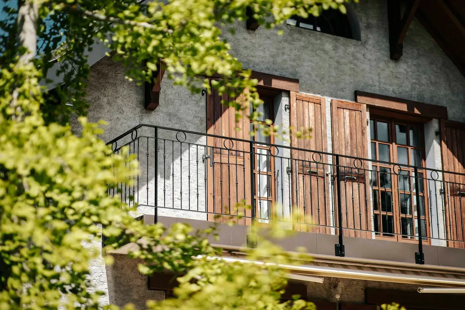 Balcon en bois protégé par un garde-corps métallique à barreaudage vertical