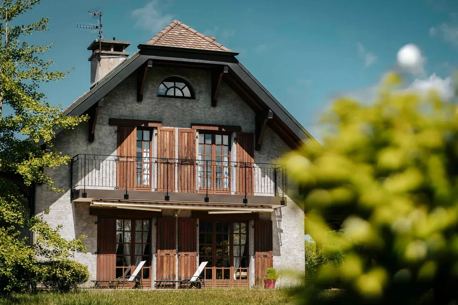 Maison de style chalet avec garde-corps métalliques aux balcons